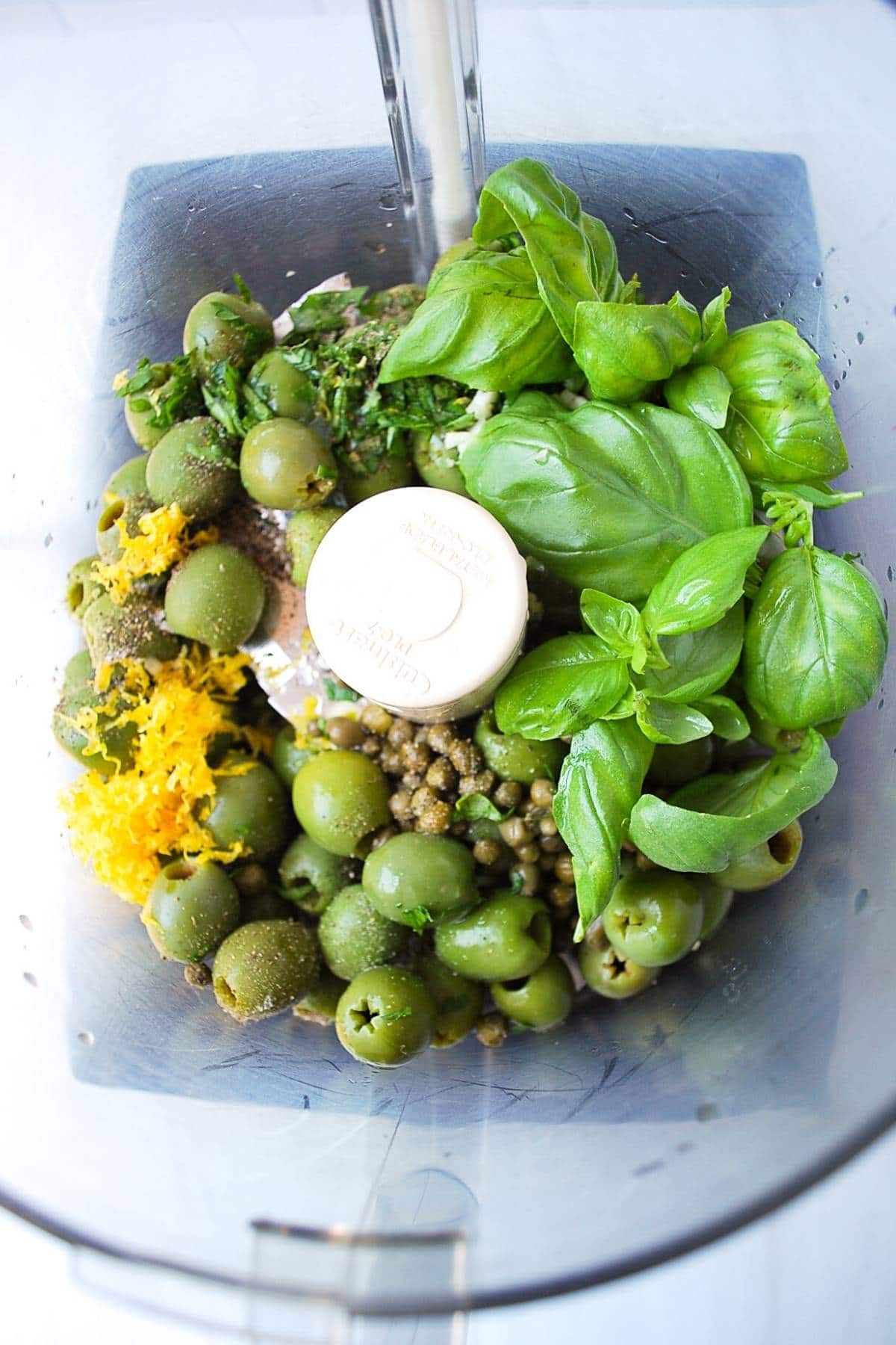 green olive tapenade ingredients in a food processor ready to pulse