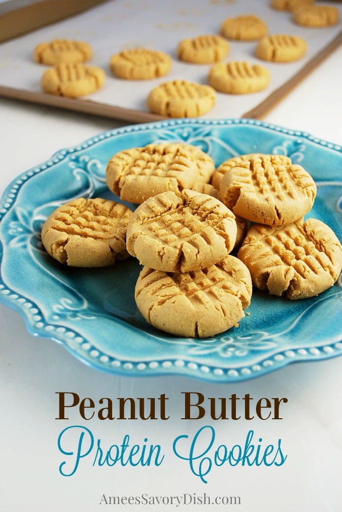 plate of peanut butter cookies with sheet pan of cookies in the background
