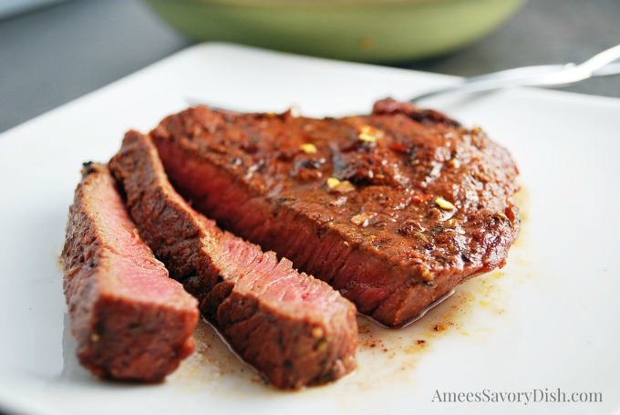 Sliced steak on a white plate with a fork