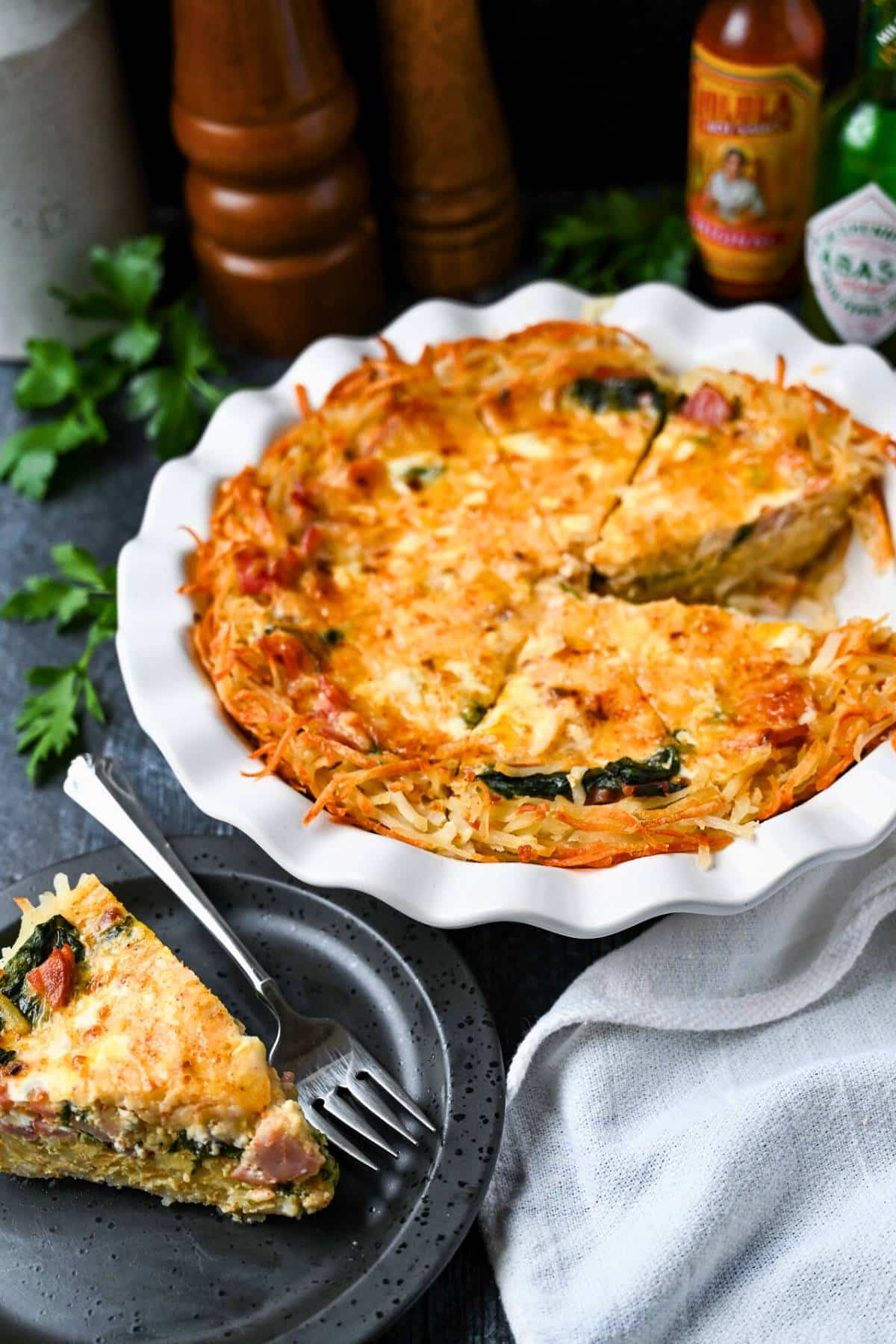 This flavorful quiche with hashbrown crust uses a combination of eggs, Canadian bacon, spinach, and cheese. Easy, filling, and delicious! via @Ameessavorydish