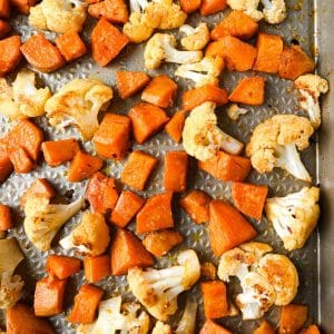 roasted sweet potatoes and cauliflower on a sheet pan