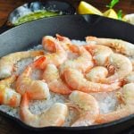 cooked shrimp over rock salt in a cast iron skillet