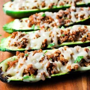 close up of grilled stuffed zucchini boats topped with melted cheese