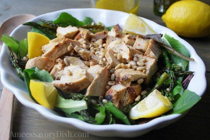 grilled chicken salad in a white bowl with lemon slices