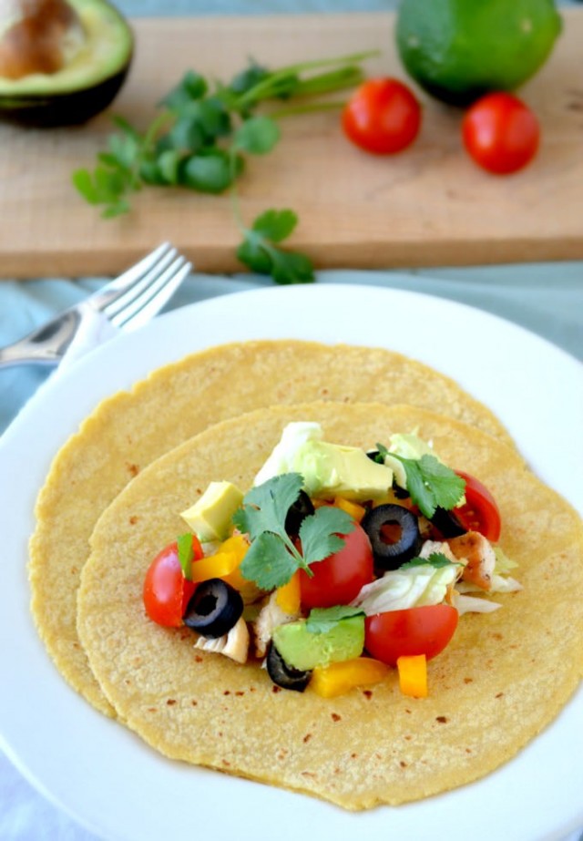 chicken taco on a white plate with toppings