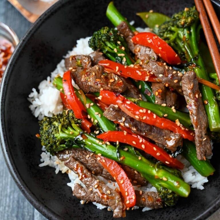looking down at a bowl of stir fry over a bed of rice