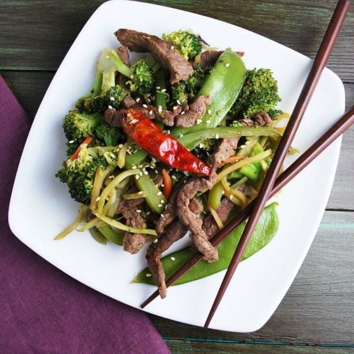 overhead photo of stir fry on plate with hot pepper and chopsticks
