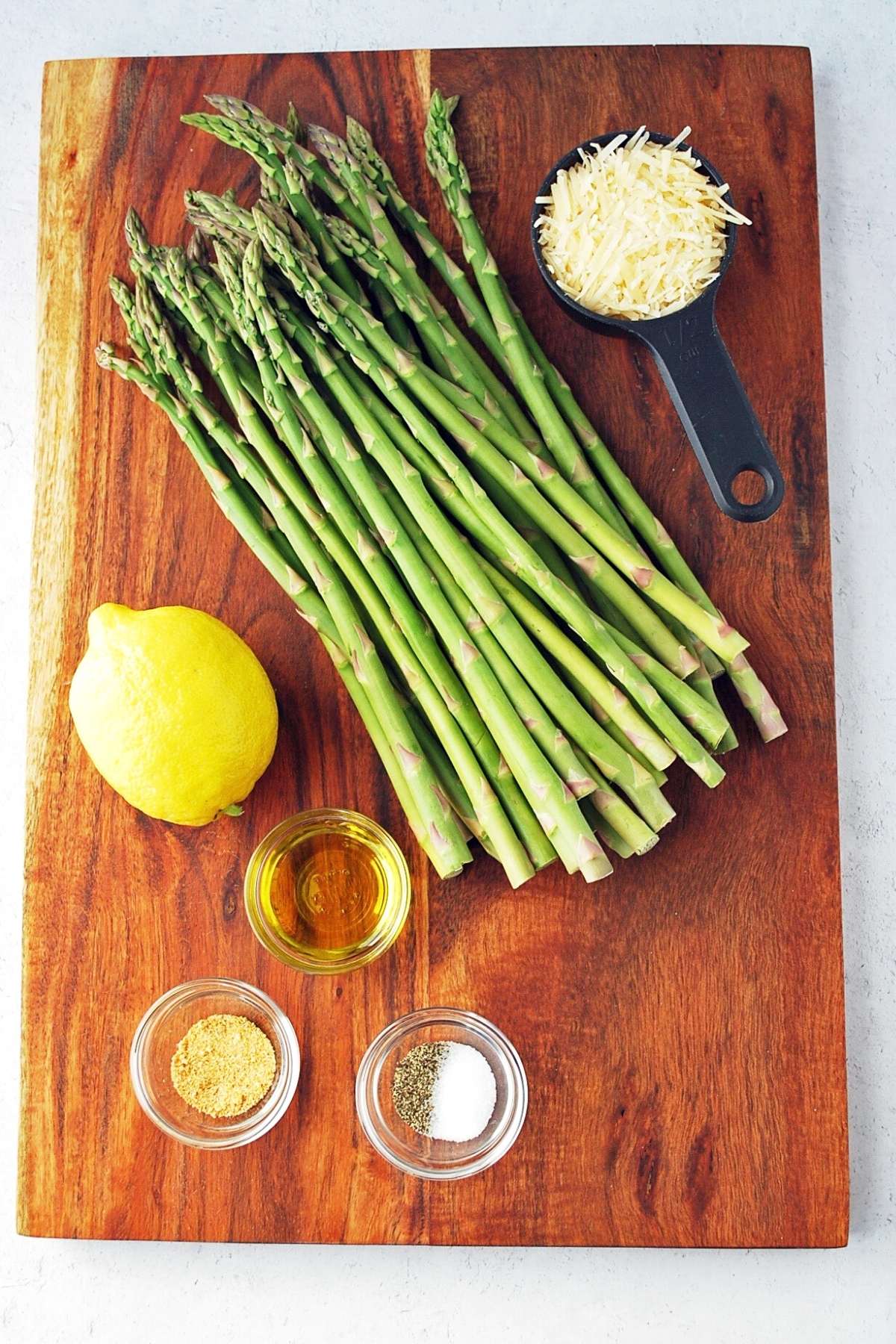 ingredients for grilled parmesan asparagus on a cutting board