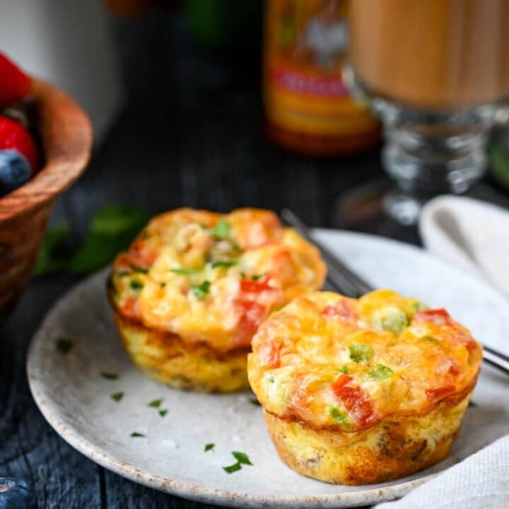 two egg muffins on a plate with a fork