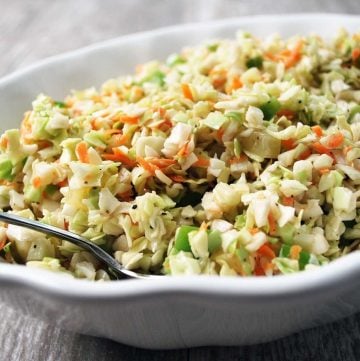 close up of vinegar slaw with chopped cabbage and carrots in a white bowl