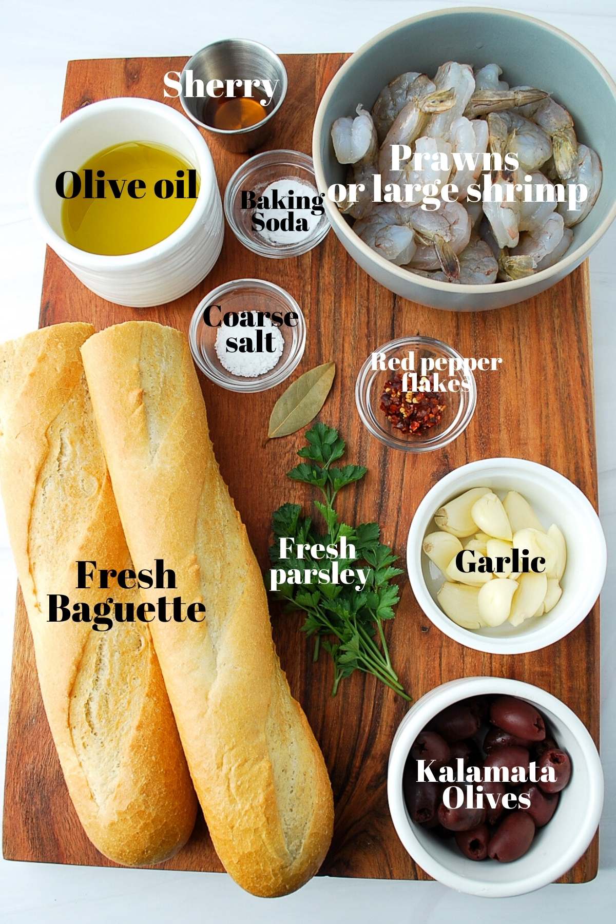 baguette, olive oil, prawns, spices, parsley, and garlic on a wood board
