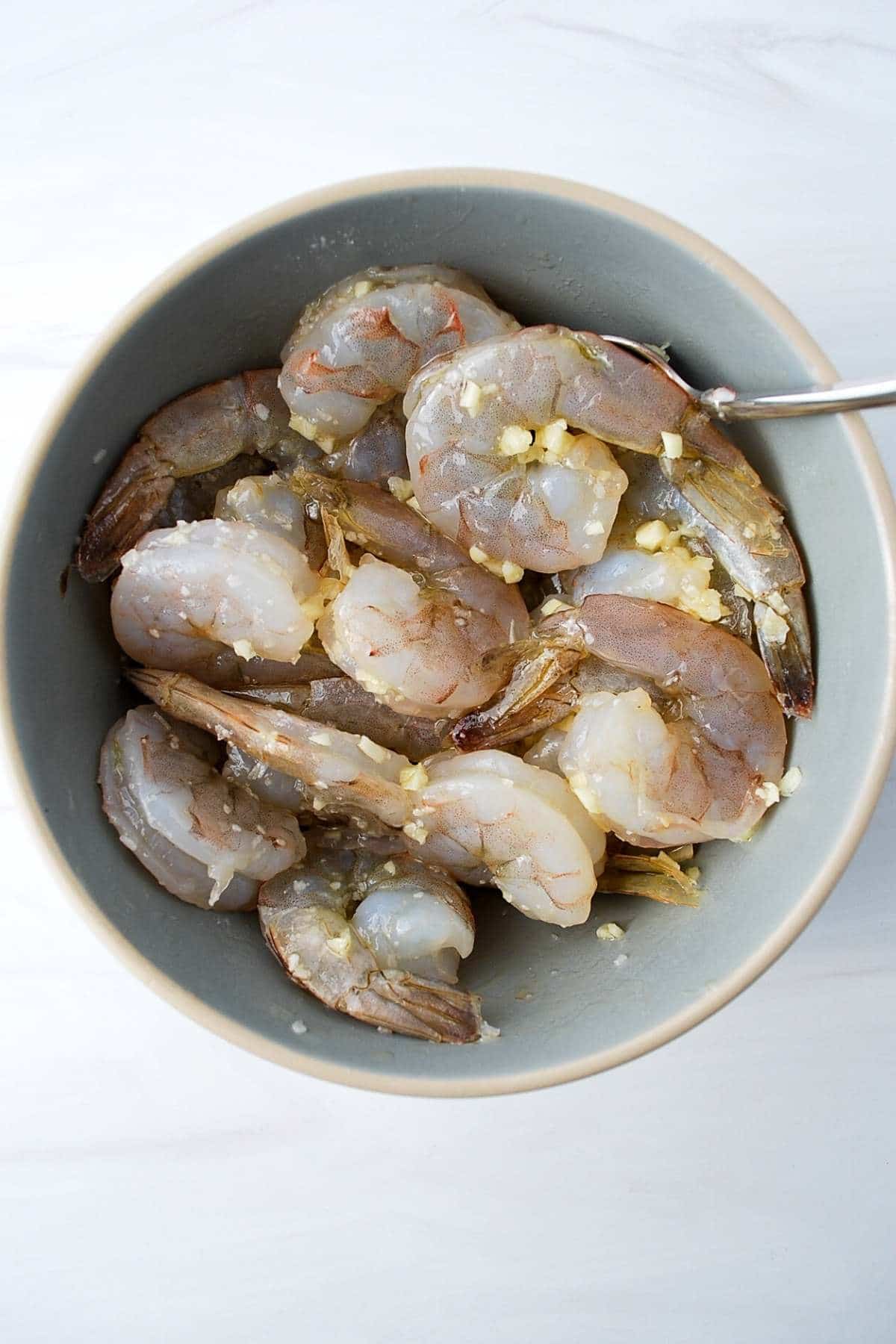 raw prawns/shrimp marinating in a garlic olive oil marinade