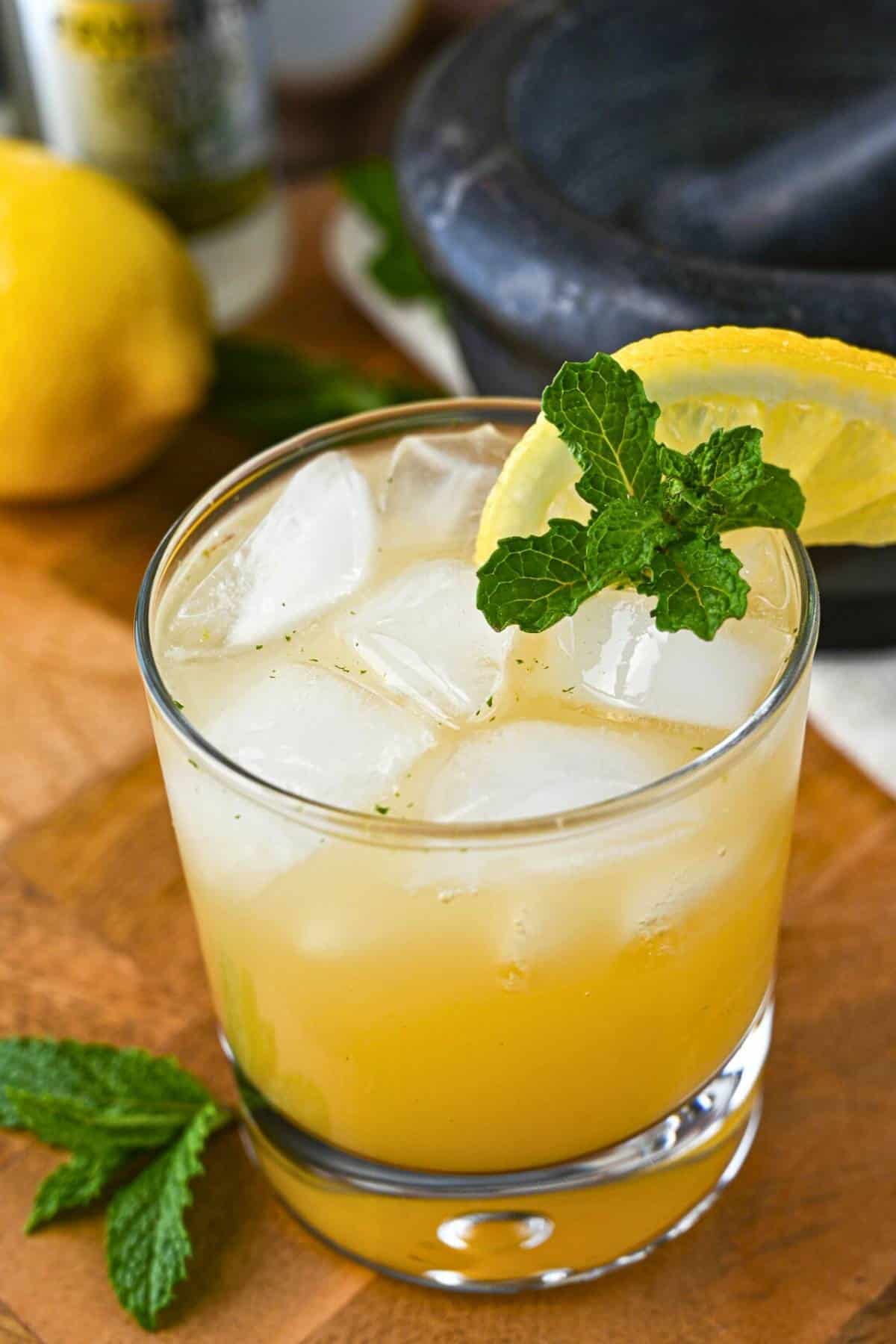  a ginger beer mocktail in a glass with ice, mint and lemon slice