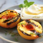 plate of grilled peaches with yogurt and mint