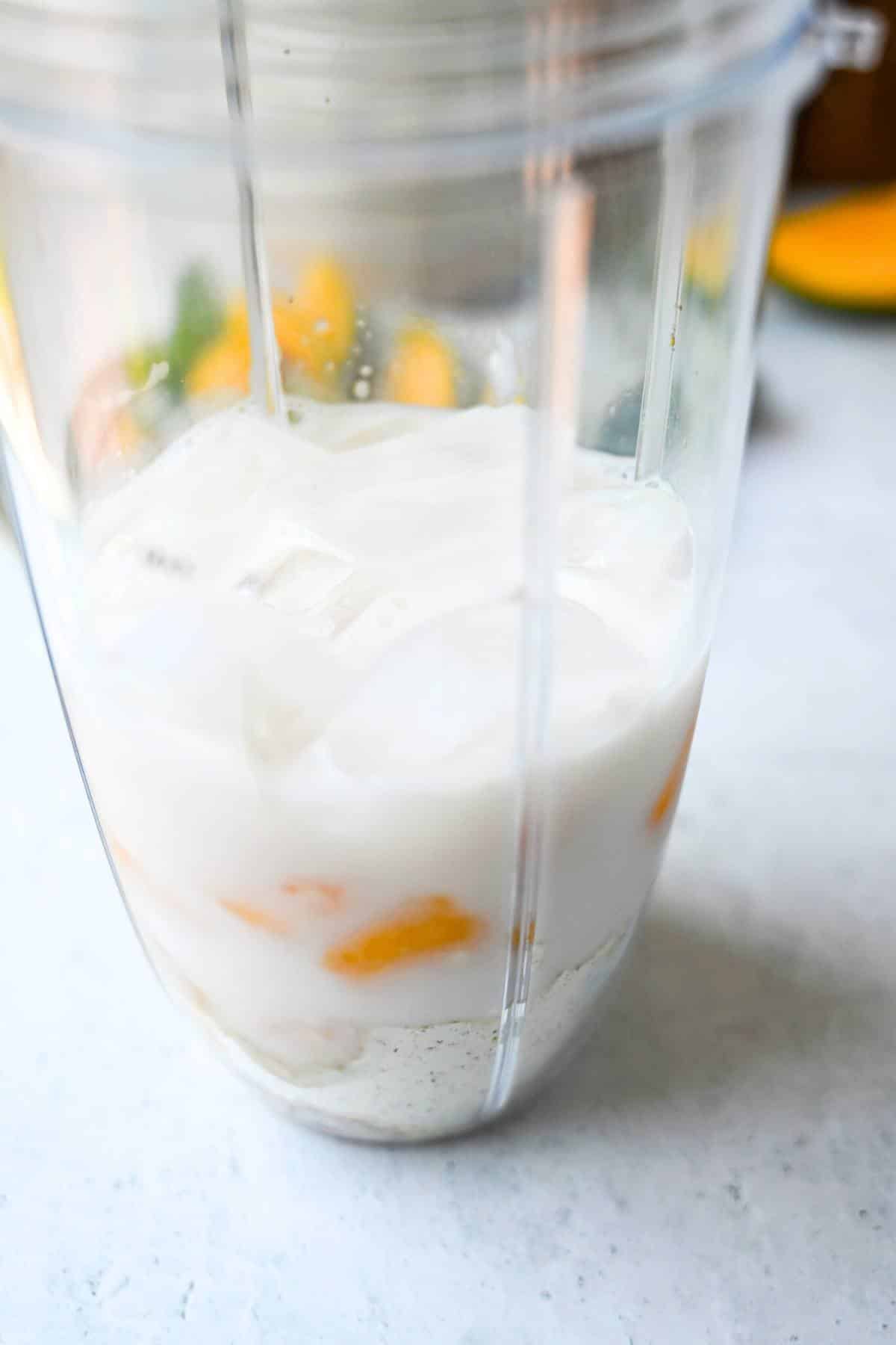 mango shake ingredients in a blender cup