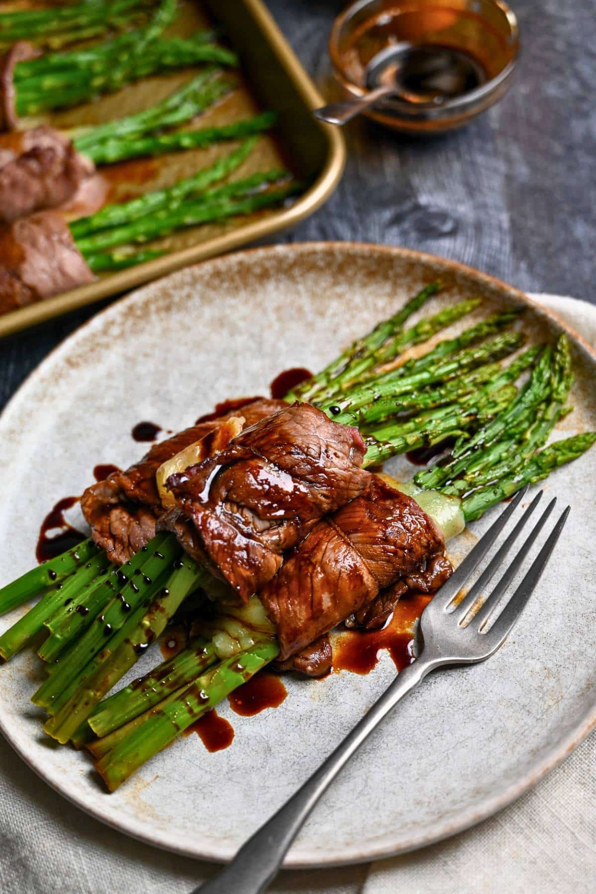 rolled steak with cheese and asparagus drizzled with balsamic vinegar