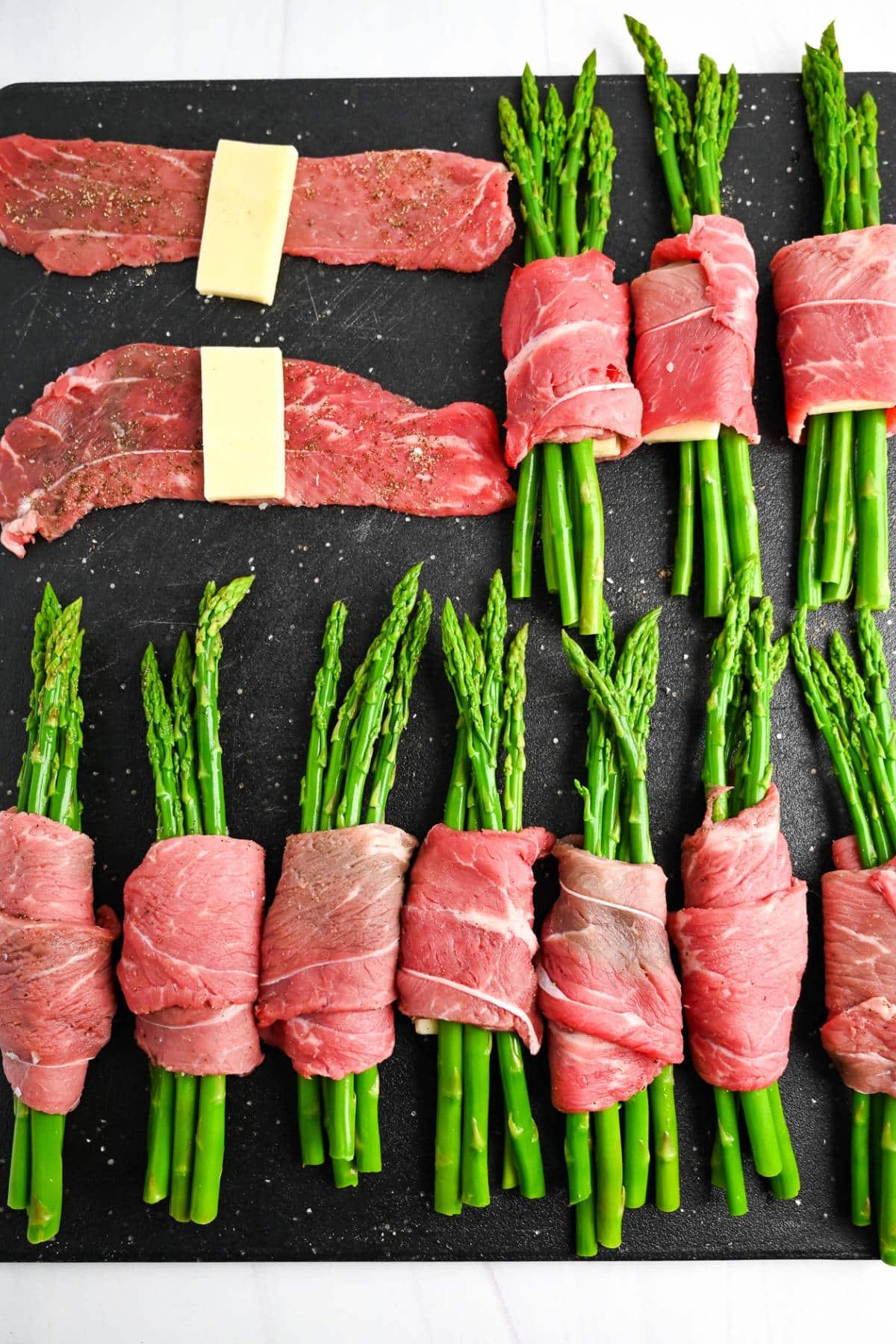 making steak, cheese, and asparagus rolls on a cutting board
