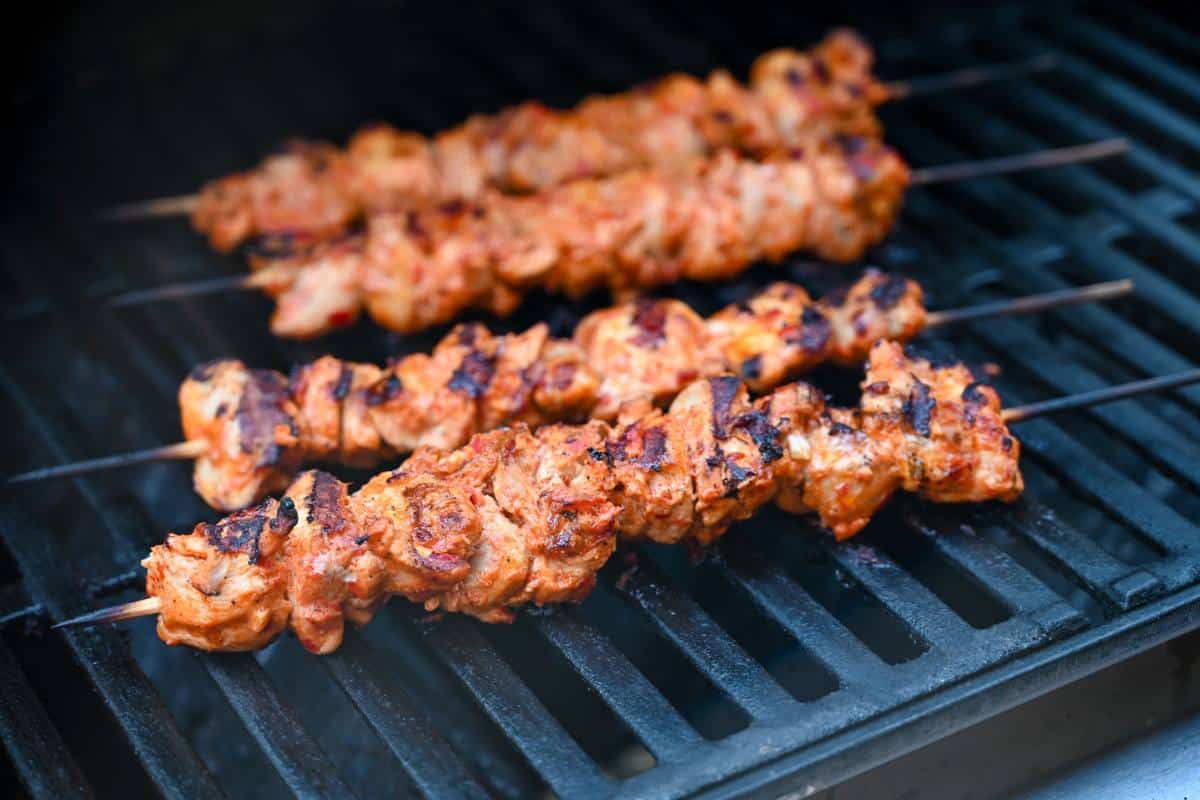 chicken skewers on a grill cooking