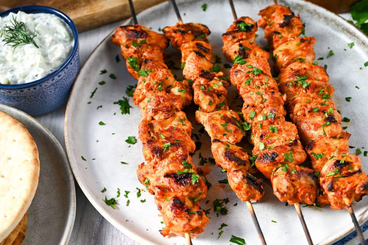 harissa chicken skewers cooked serving on a plate with parsley and spicy tzatziki sauce