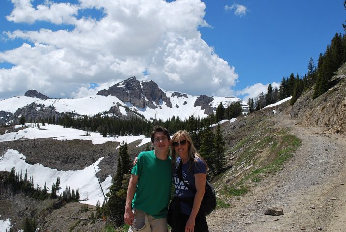 Two people standing in front of a mountain