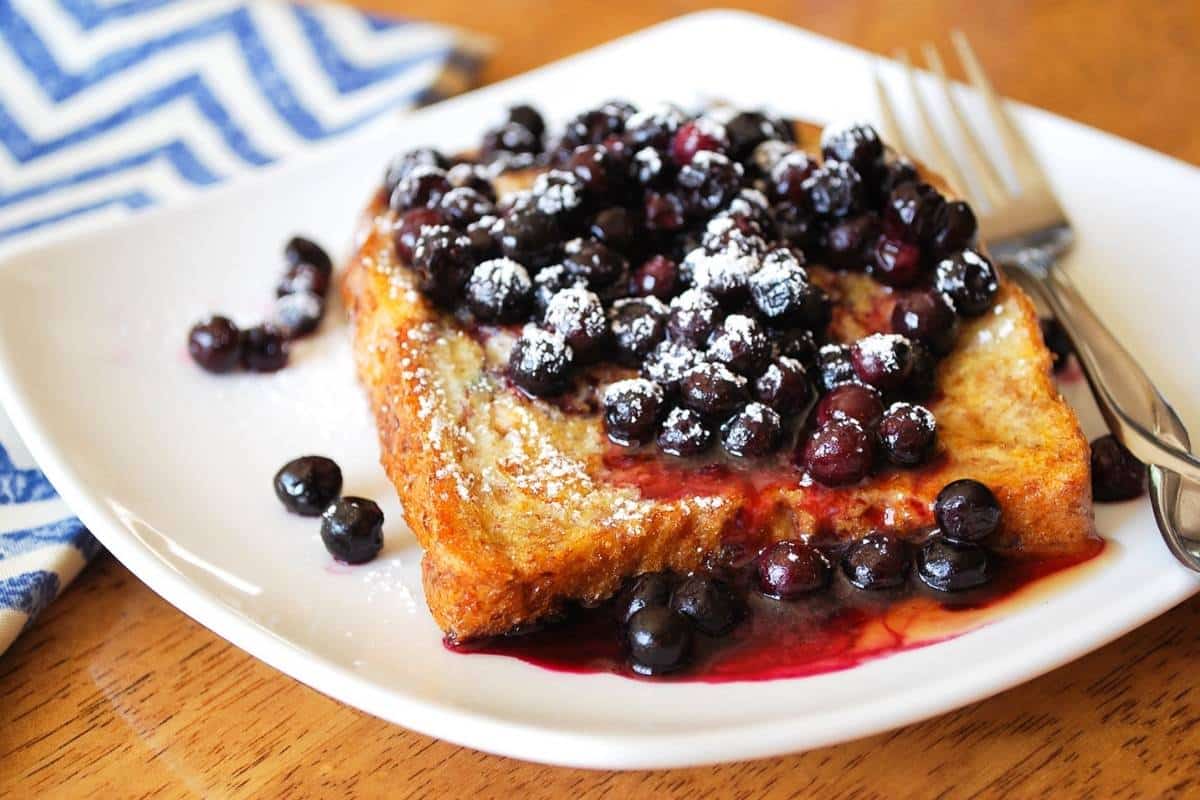 whole grain anabolic french toast on a plate topped with wild blueberries