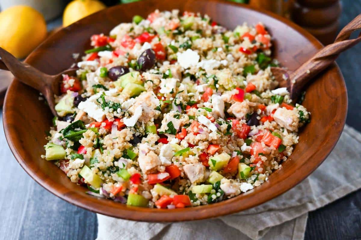 chicken quinoa bowl with veggies in a large wood salad bowl