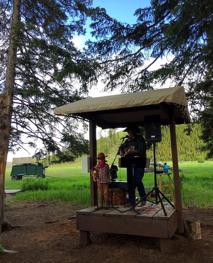 A cowboy singing on a wooden platform