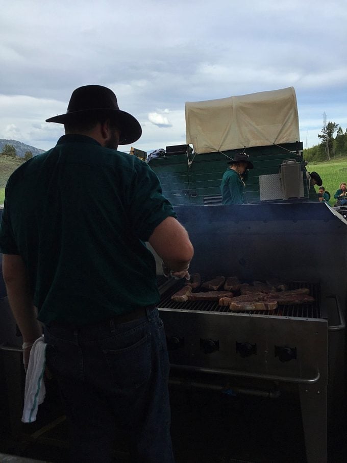 A person that is cooking food at the cowboy cookout