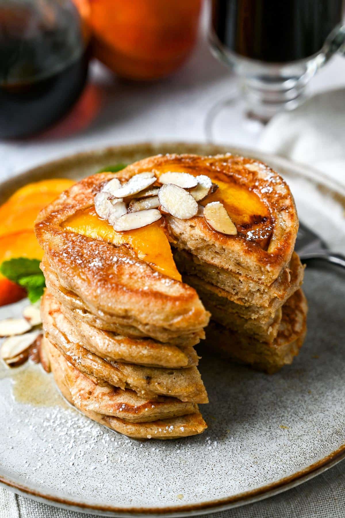 a sliced stack of peach pancakes with a cup of coffee