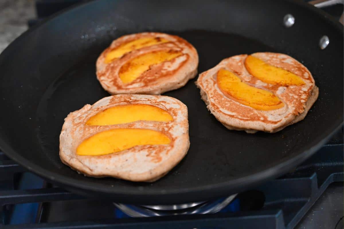 cooked peach pancakes in a skillet