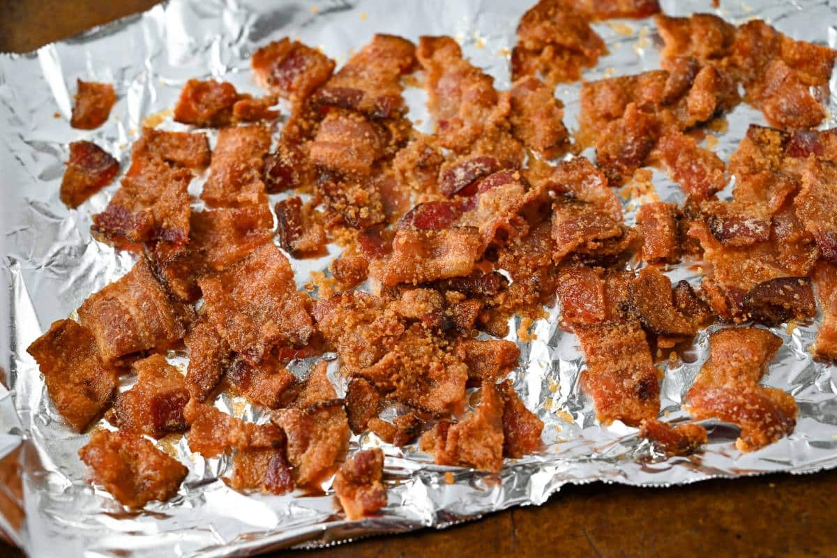 chopped bacon with melted maple sugar on a foil lined baking sheet