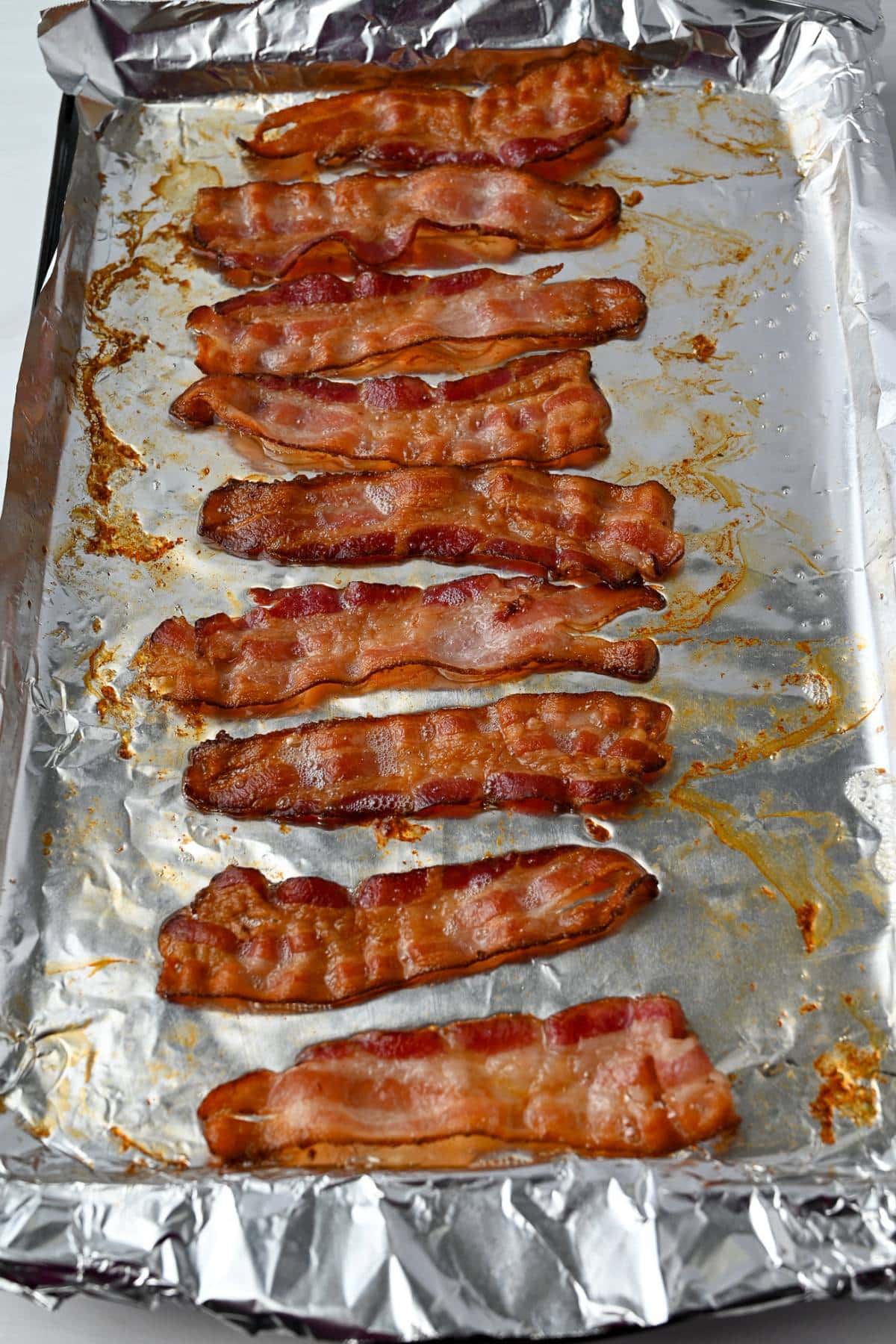 oven-cooked bacon on a foil lined baking sheet