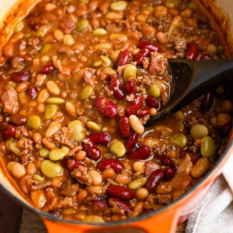 baked beans in a dutch oven with a spoon