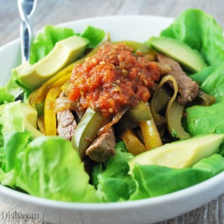 A bowl of Fajita salad with sliced avocados on top