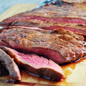 close up photo of a sliced flank steak on a cutting board
