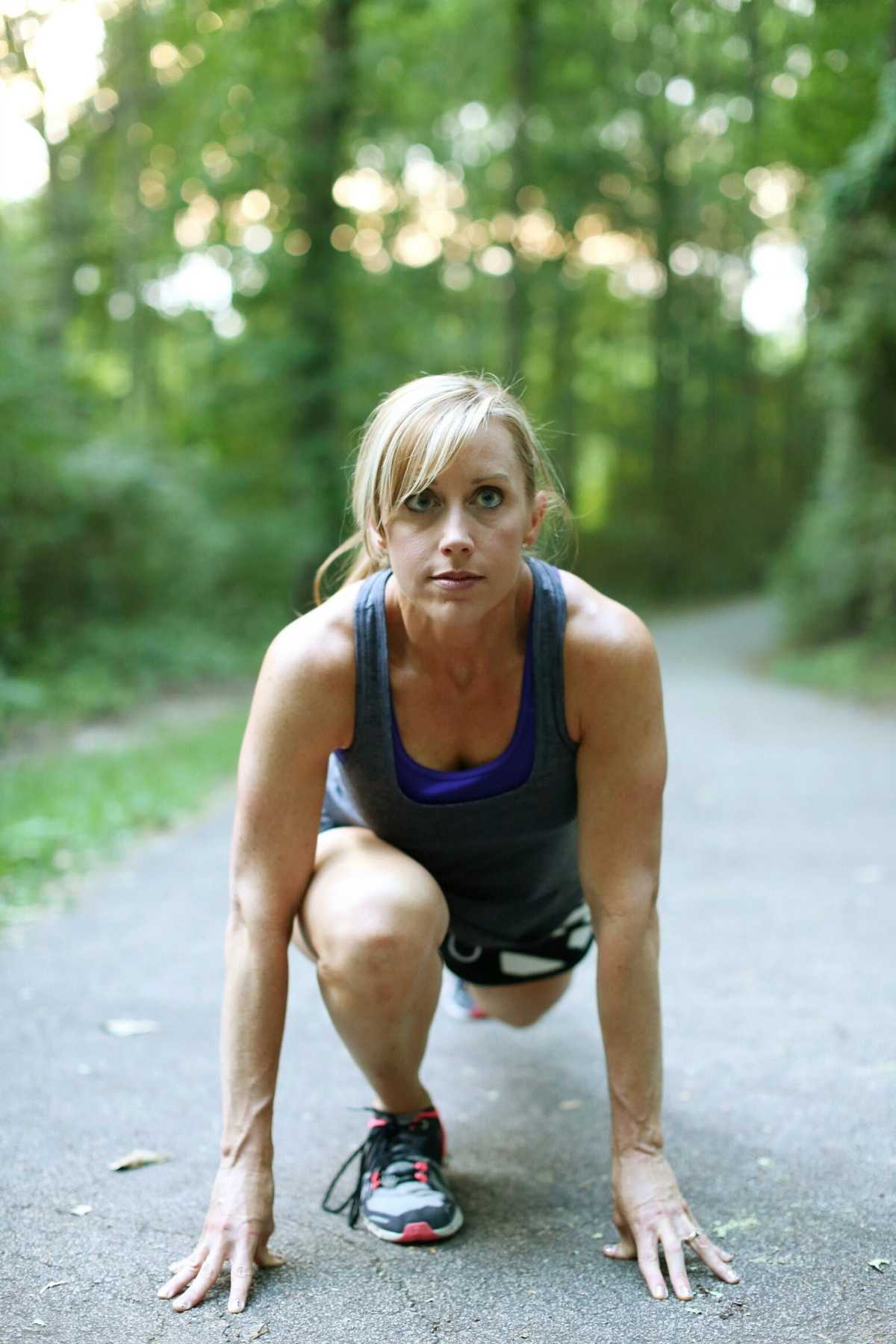 woman in a running stance outside on pavement