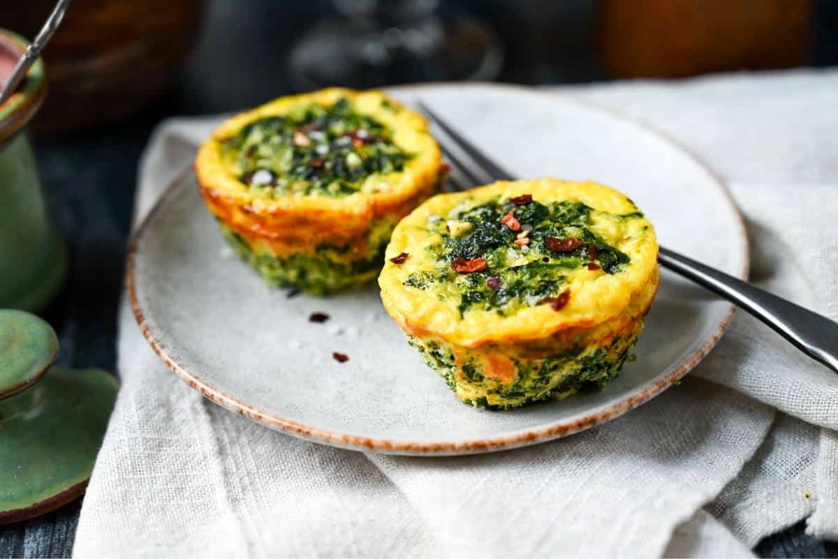 spinach and feta egg bites on a plate with a napkin underneath