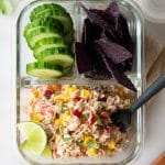 Mexican tuna salad with cucumbers and tortilla chips in a meal prep container
