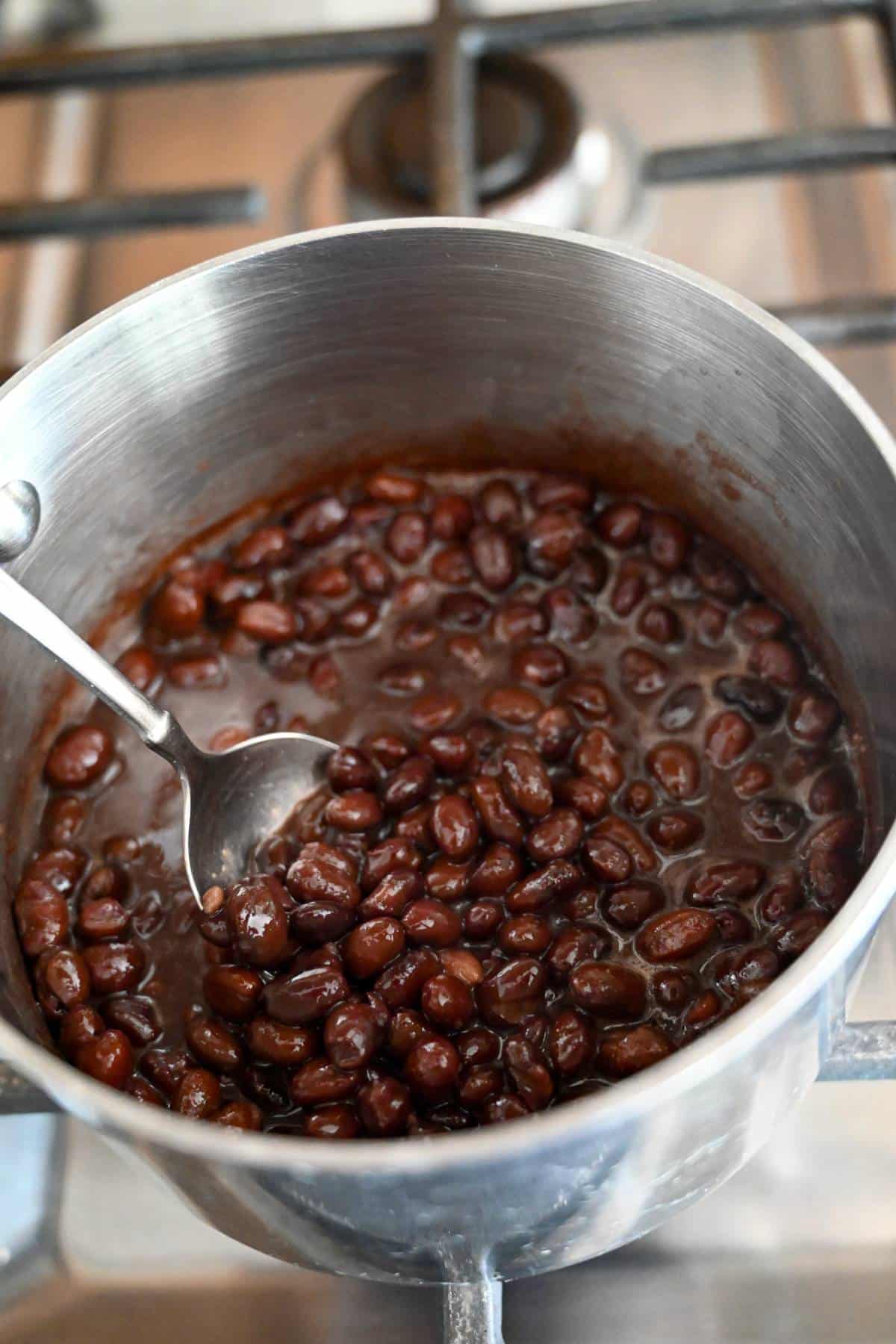 black beans simmering in a pot on the stove