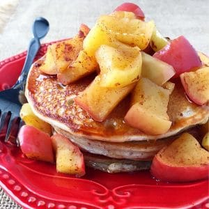 close up of a plate of stacked protein pancakes topped with cinnamon apples