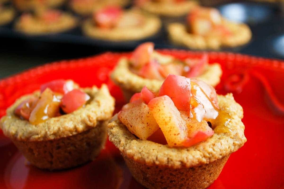 side view of apple filled tartlets on a plate