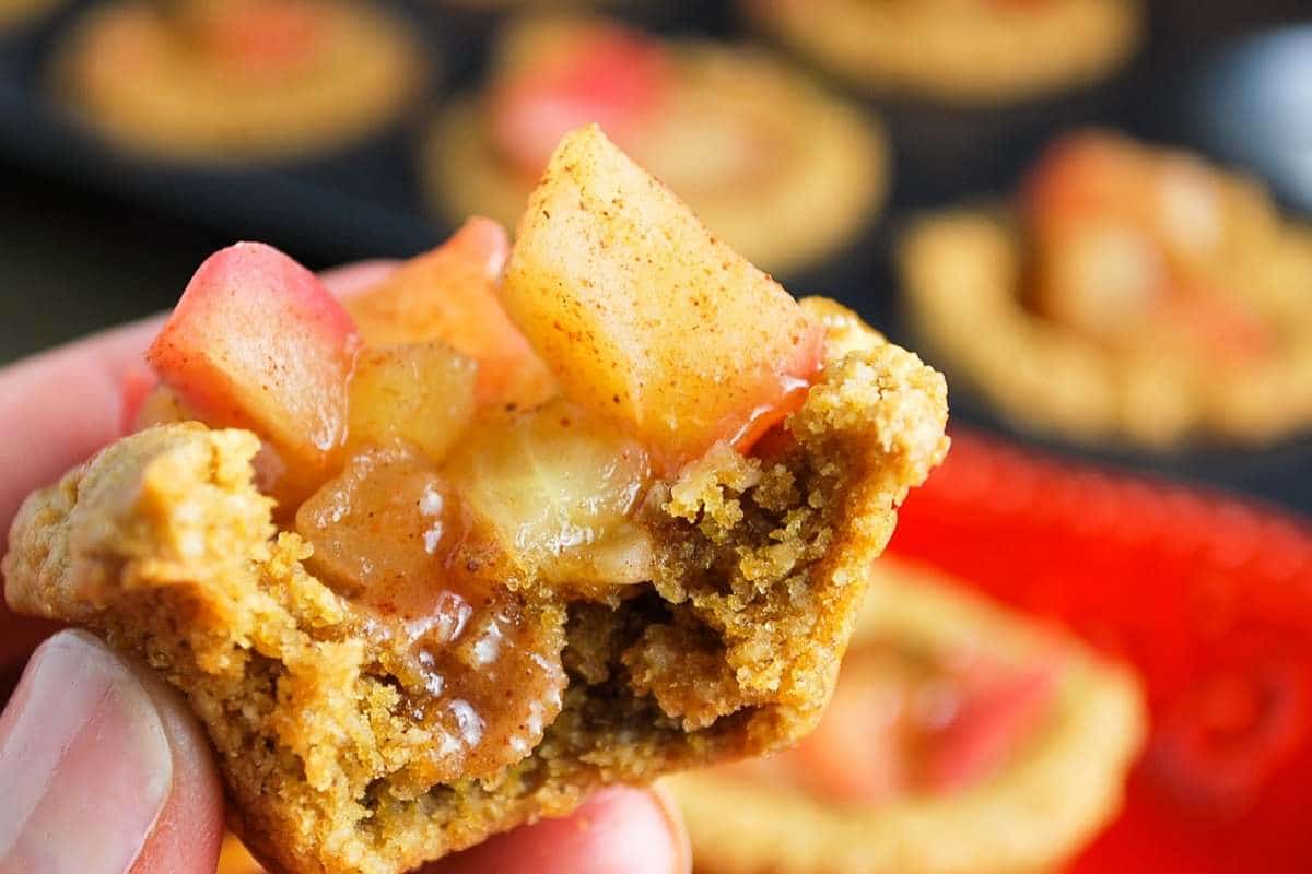 a peanut butter apple caramel tartlet with a bite out of it