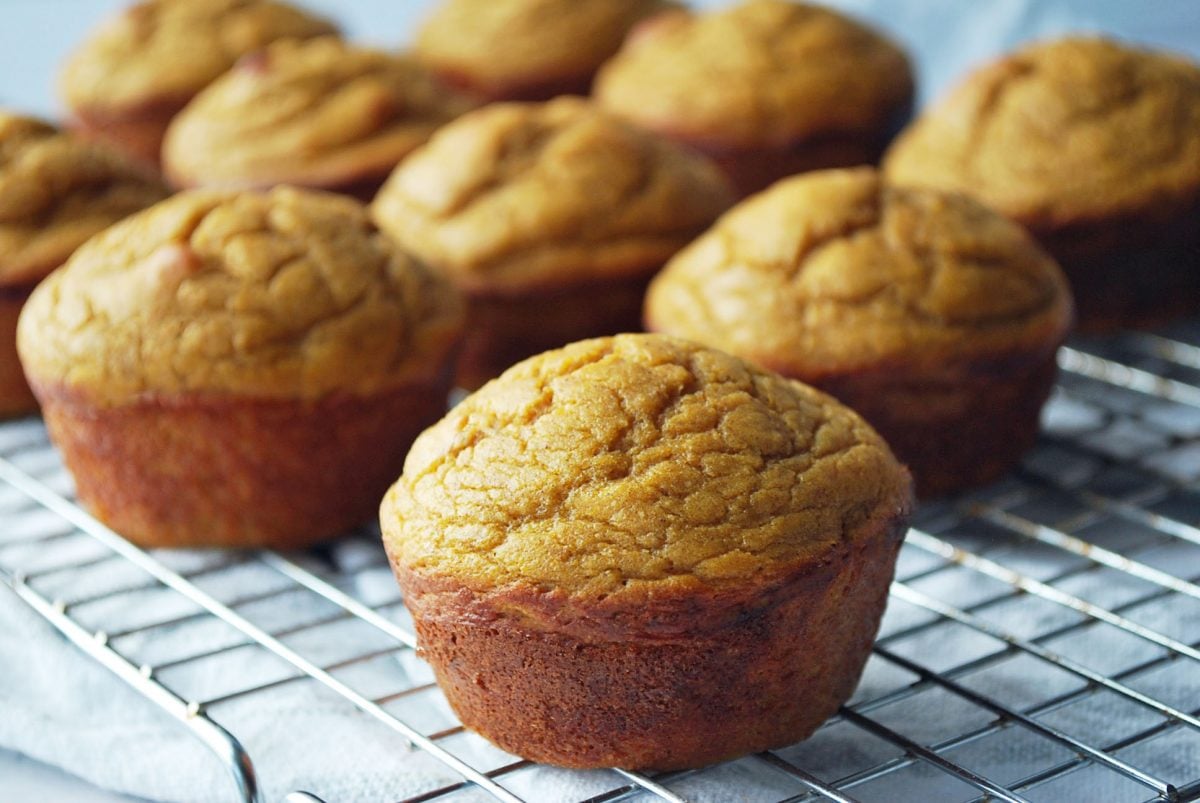 sweet potato muffins on a cooling rack with a napkin underneath