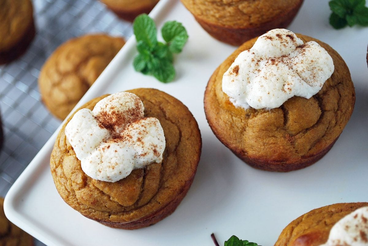 close up of marshmallow topped muffins on a platter with sprigs of fresh mint