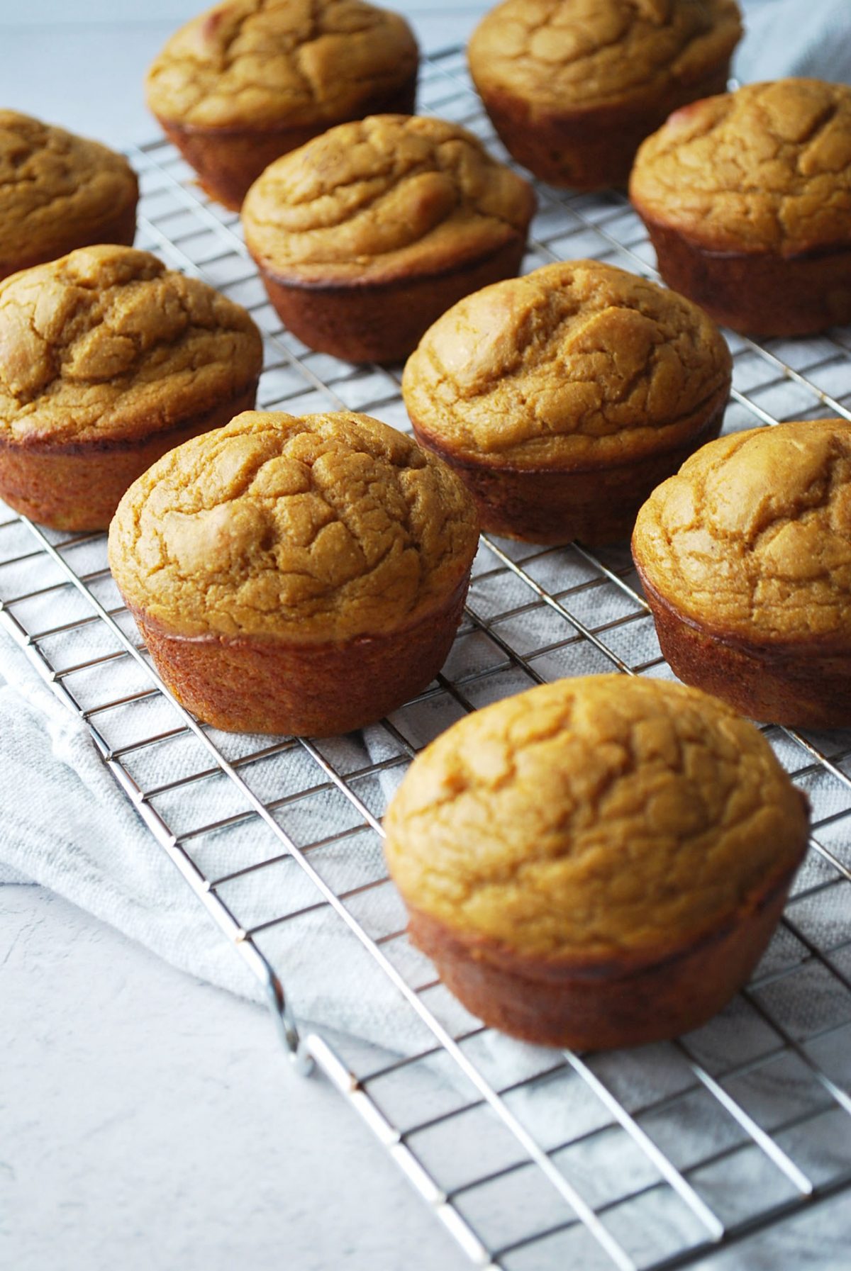 muffins on a cooling rack on top of a kitchen towel