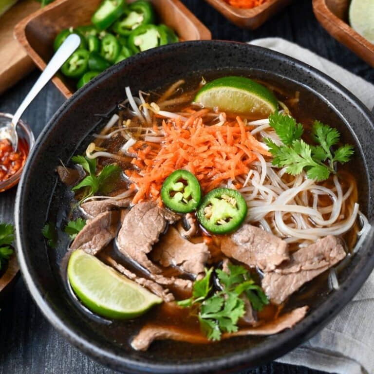 close up of a bowl of flank pho loaded with toppings