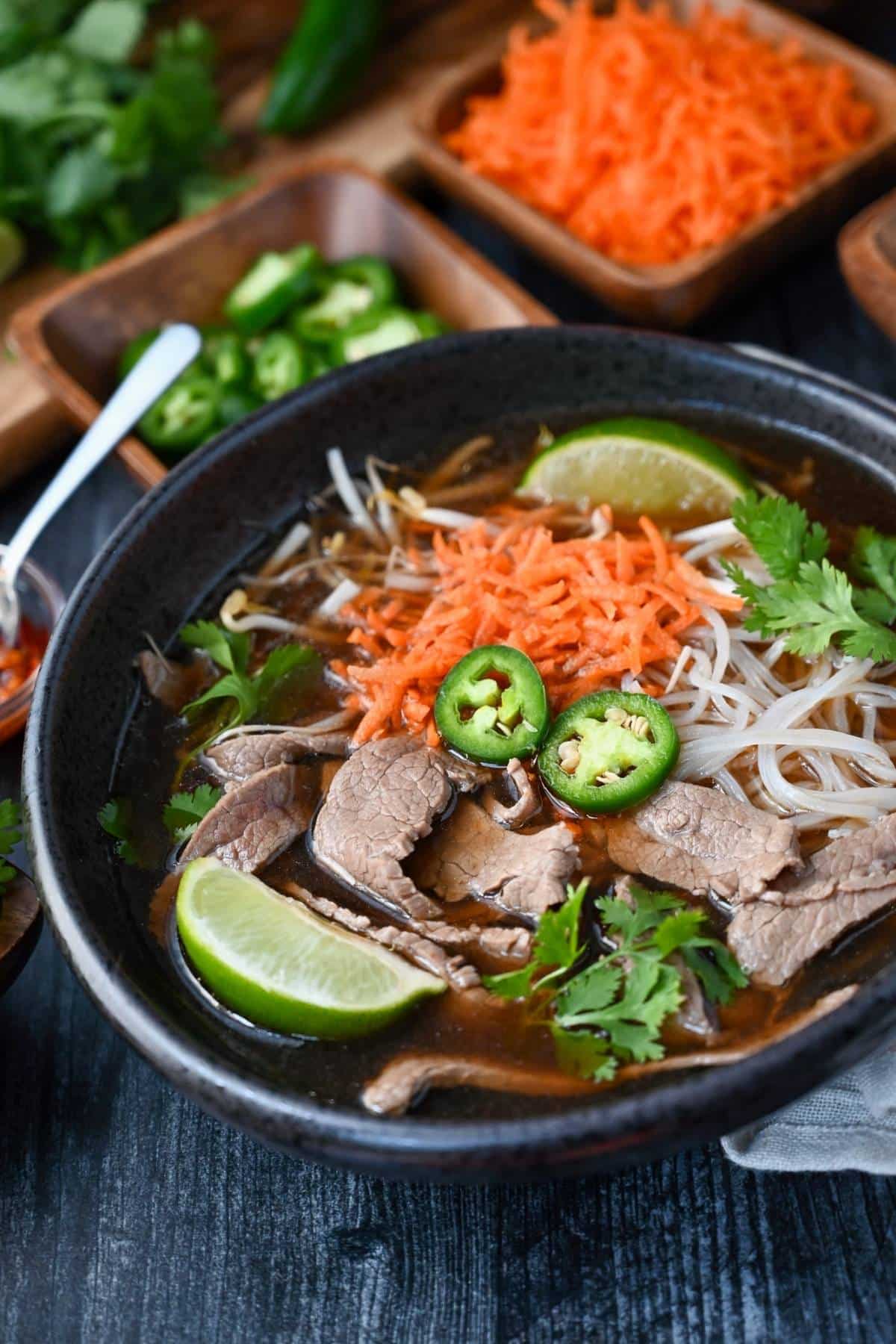 a bowl of pho with all the toppings