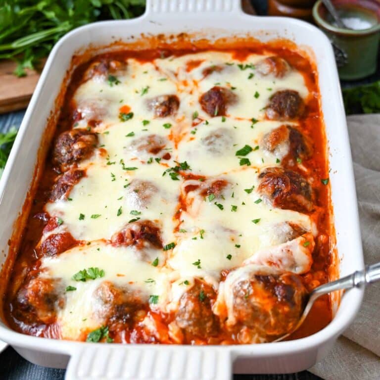 spaghetti squash casserole with meatballs and cheese with a serving spoon