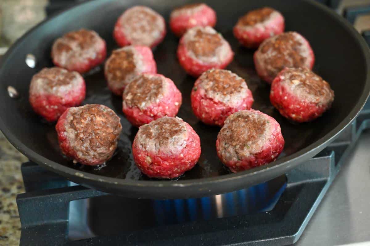 sauteeing meatballs in a skillet