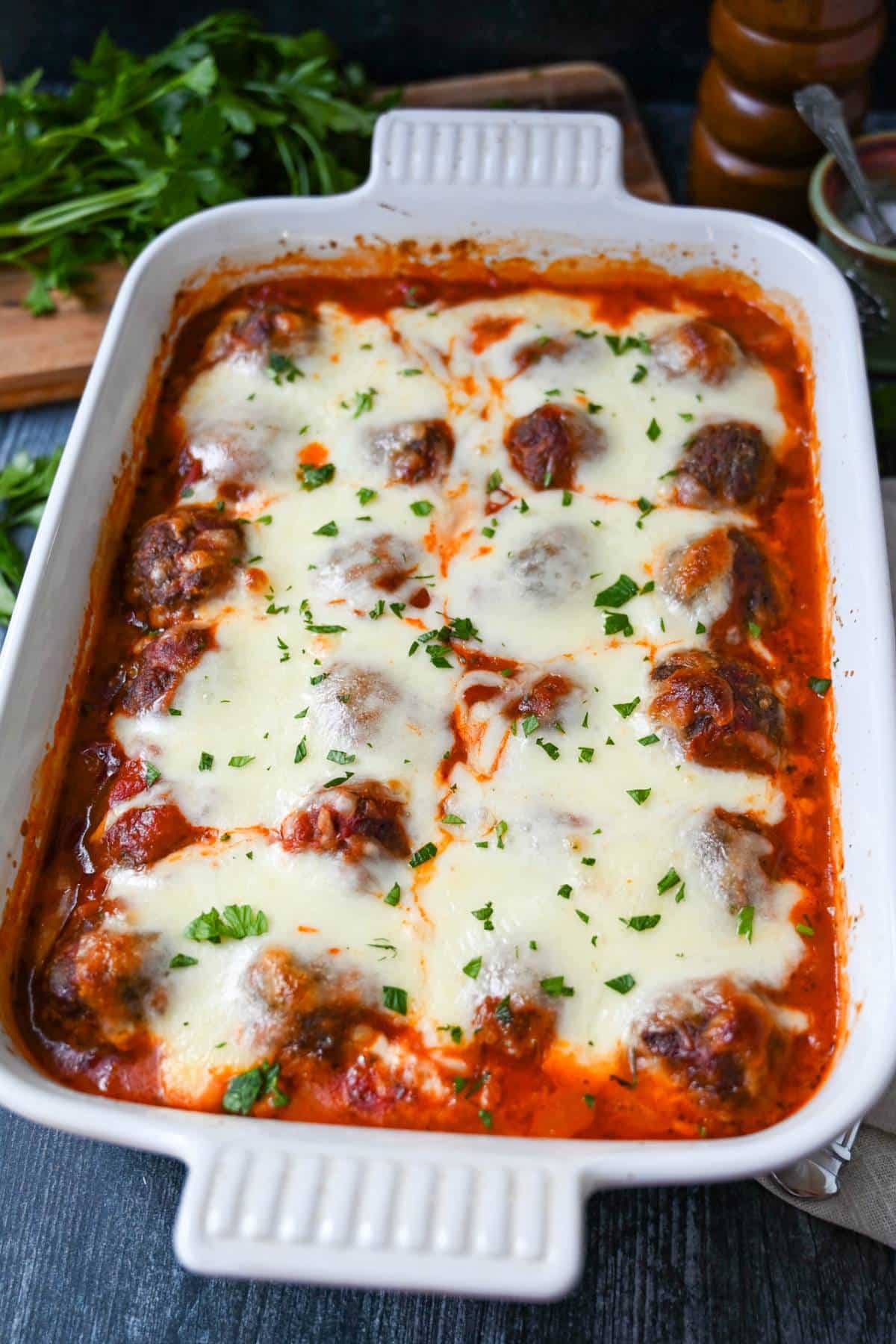 a pan of meatball casserole with fresh parsley on top